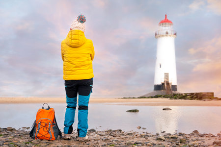 woman enjoying life on seaside against lighthouse on sunny Autumn day. Travel Lifestyleの写真素材