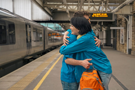 couple at railway station meeting hugging waiting for train on platformの写真素材