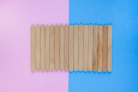 Clean wooden or bamboo planks or sticks on trendy pink and blue background with copy space