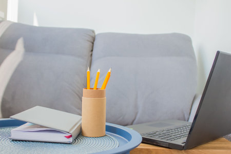 Home office of creative entrepreneur with black laptop, modern creative workspace with yellow...