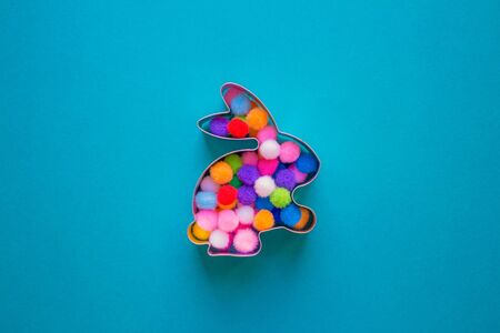 Rabbit bunny shaped form for gingerbread decorated with colorful balls inside on blue turquoise background with copy space. Easter conceptの写真素材