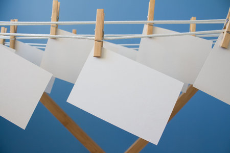 Notepaper pin with clothespins hanging on rope as creative background for your design with copy...