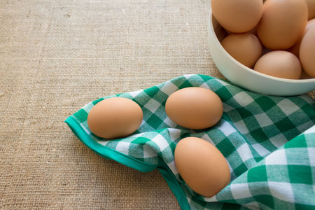 Raw fresh organic chicken eggs from local farmer market on green tablecloth, selective focus
