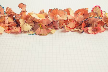 Color pencils shavings on white school notebook page as creative background with copy space. Back to school conceptの写真素材