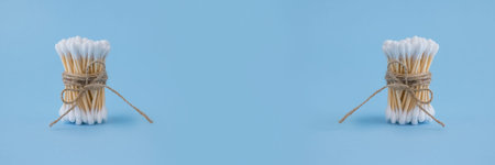 Banner with bamboo cotton sticks bound with flax or hemp cord on blue background. Copyspace for your...