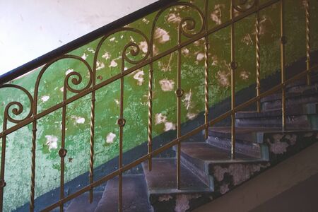 Classic traditional vintage metal baluster against aged green wall in abandoned historical building in Lviv, Ukraineの写真素材