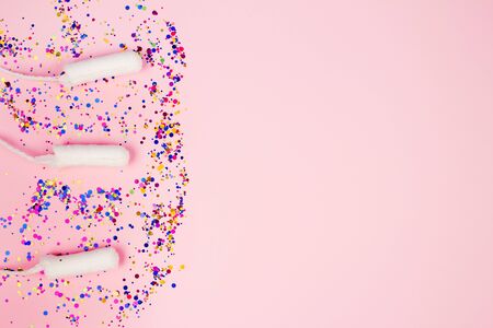 Set of clean cotton tampon with colorful sparkles on pastel pink background with copyspace - critical days and menstruation concept. Flat lay composition for Menstrual Hygiene Day conceptの写真素材