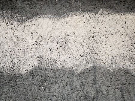 Grey plastered wall with white strip as creative abstract brutal background with copy space for your text, real stucco pronounced texture. Selective focusの写真素材