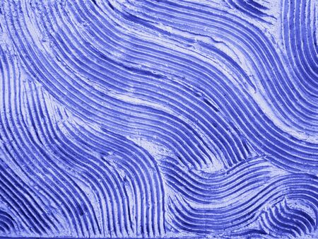 Decorative plastered wall as creative abstract background in blue color with copy space for your text, real stucco pronounced waved texture. Selective focusの写真素材