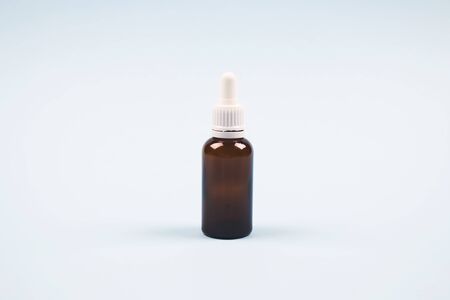Bottle of essential oil, collagen or hyaluronic acid on light blue background. Mockup, copyspace for your design or text. Modern beauty and apothecary conceptの写真素材