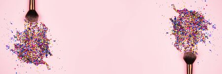 Banner with professional cosmetic makeup brushes with explosion of shiny colorful sparkles on pastel pink background with copyspace for your text. Creative make-up conceptの写真素材