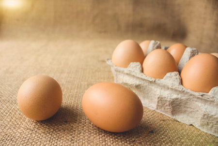 Front view on fresh organic chicken eggs from local farmer market in paper packaging box standing on...