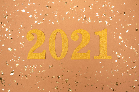 Festive background with 2021. Golden numbers on craft paper backdrop with holographic sparkles around - Happy New Year celebration concept. Christmas holidays 2021 celebrationの写真素材