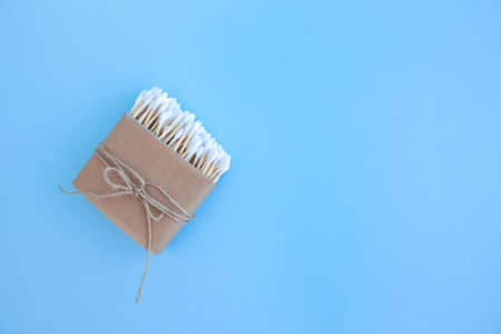 Mockup image of bamboo cotton buds in paper box, bound with flax or hemp cord on blue background. Zero waste and sustainable lifestyle concept, eco friendly bathroom essentials. Copyspaceの写真素材