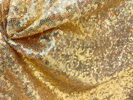 Golden sequined fabric texture - shiny golden sparkling sequins background. Festive, carnival or...