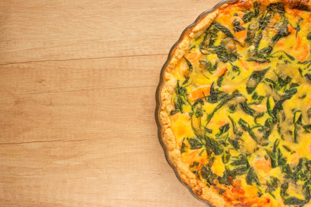 Salmon fish and spinach leaves quiche pie - homemade recipe pie on wooden table background with copy space for your text, selective focus. Top viewの写真素材