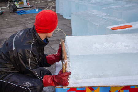 Lviv, Ukraine - January 02, 2021 : an artist making ice sculpture during Christmas holidays festival in Lviv. Ice and snow sculpture conceptのeditorial素材