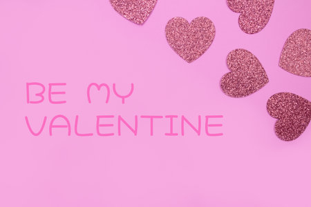 Be my Valentine greeting card with pink glitter hearts on pink background - St. Valentine's Day celebration concept. Love backdrop for greeting card, copy space for your text. Selective focusの写真素材