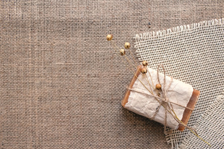 Top view on handmade natural soap bar with flax flower on rustic background with copy space. Home spa products made with natural ingridients and organic essential oils. Skincare conceptの写真素材