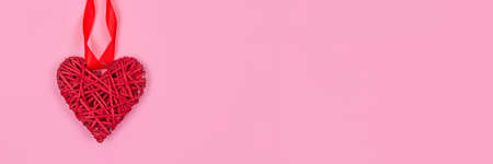 Banner with red heart - as a symbol of love, on pink background with copy space for your text - St. Valentines Day celebration concept. Love backdrop for greeting card, selective focusの写真素材