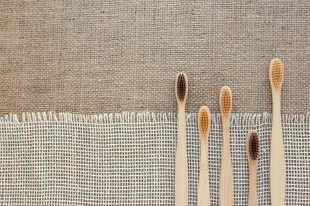 Set of natural bamboo toothbrushes on rustic background with copy space. Sustainable lifestyle, bathroom essentials in zero waste home. Dental health concept. Mockup image. Selective focusの写真素材