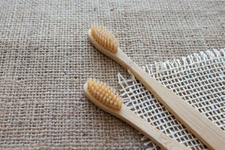 Natural bamboo toothbrushes on rustic background with copy space. Sustainable lifestyle, bathroom essentials in zero waste home. Dental health concept. Mockup image. Selective focusの写真素材