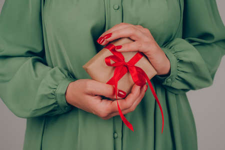 Young woman holding Christmas present box decorated with red bow. Christmas holidays, New Year celebration concept. Preparing family gifts for Christmas, selective focusの写真素材