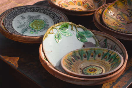 Antiques on flea market or traditional festival - vintage handmade ceramic dishes and plates from Kosiv region, Ukraine. Collectibles memorabilia and garage sale concept, selective focusの写真素材