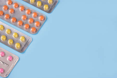 Assorted medicine pills, capsules and tablets in blisters on blue background with copyspace for your text. Immune system vitamins and supplemets. Dietary bio supplements. Selective focusの写真素材