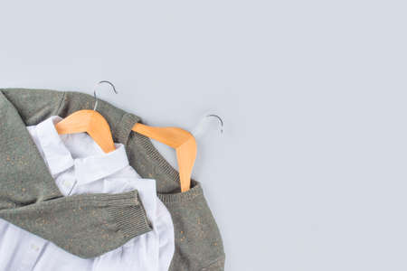 Sweater and white shirt, clothes on gray background with copy space. Clothing donations, conscious, environmentally friendly consupmtion - new trends in shopping. Slow fashion concept. Selective focusの写真素材