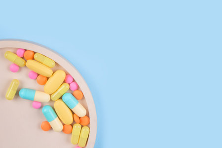 Immune system vitamins and supplemets. Dietary bio supplements. Assorted multicolored medicine pills, capsules and tablets on blue background with copy space for your text. Selective focusの写真素材