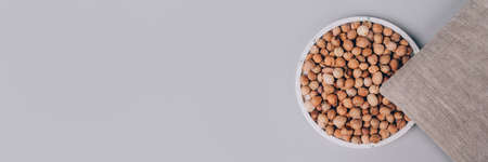 Banner with heating cherry pits pad on gray background with copy space - cherry stone thermal pillows. Alternative medicine and therapy, microwaveable pit sack for spa massage, chiropractic careの写真素材