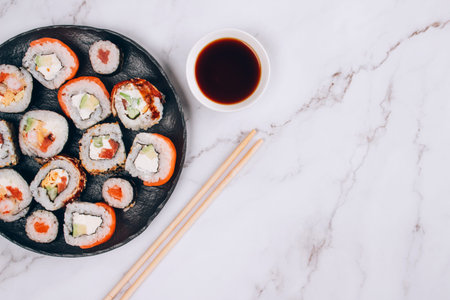 Sushi bar lunch menu, top view - different sushi rolls with salmon, avocado and smocked eel on white marble table background. Online order delivery food online, takeout food concept. Selective focusの写真素材
