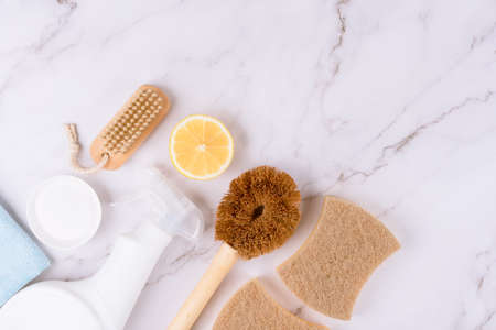 Set of natural household cleaners made of simple eco ingredients, bamboo brush, organic dishcloth, lemon, baking soda on marble background with copy space. Green cleaning conceptの写真素材