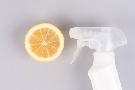 Spray bottle with natural homemade household cleaner or air freshener made with lemon on light gray background. Bio organic detergent products, home cleaning concept. Green householdの写真素材