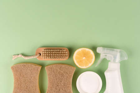 Organic household cleaners kit - bamboo brush, organic dishcloth, lemon, baking soda, citric acid and spray bottle with cleaning liquid on light green background with copy space. Mockup. Green cleaning conceptの写真素材