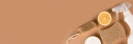 Banner with organic household cleaners kit - bamboo brush, organic dishcloth, lemon, baking soda, citric acid, spray bottle with cleaning liquid on beige background with copy space. Mockup. Green cleaning conceptの写真素材