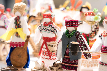 Dolls wearing ethnic ukrainian traditional embroidered costumes, vyshyvanka - traditional embroidered clothes on flea market or national festival. Vintage goods on flea market. Symbol of Ukrainian cultureの写真素材