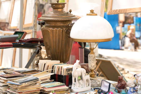 Lviv, Ukraine - May 1, 2022 : Different antiques on flea market or traditional festival - vintage lamp, old books, postcards and other vintage things. Collectibles memorabilia or garage sale conceptのeditorial素材