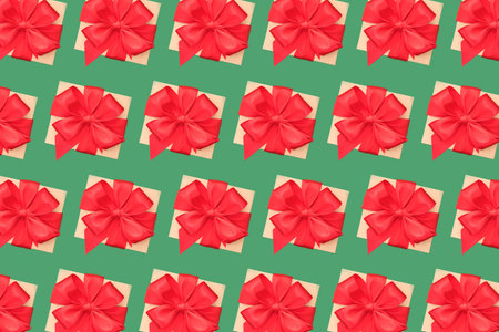 Flatlay composition with many present boxes with red ribbon bow on green background. Birthday or...