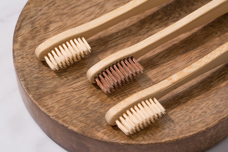 Set of natural wooden toothbrushes wooden tray. Natural bath products and zero waste concept,...