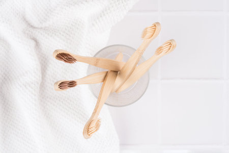 Top view on natural biodegradable eco-friendly wooden toothbrushes with BPA free bristles in glass...