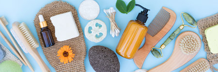 Banner with natural bath accessories and self-care products for body and skin care over blue...