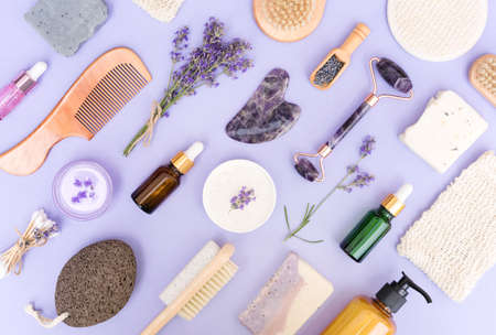 Natural bath accessories and self-care products for body and skin care over purple background. Natural lavender cosmetics for beauty treatments, eco living concept. Flat lay styleの写真素材