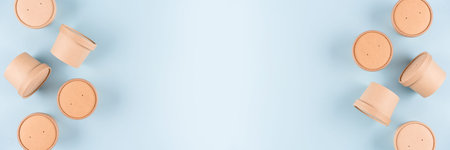 Banner with eco paper food containers - takeaway soup or ice cream containers over light blue...