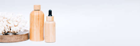Banner with cosmetic self-care products with natural Dead Sea minerals in wooden bottles against white background copy space. Algae oil or sea minerals based beauty products for skin careの写真素材