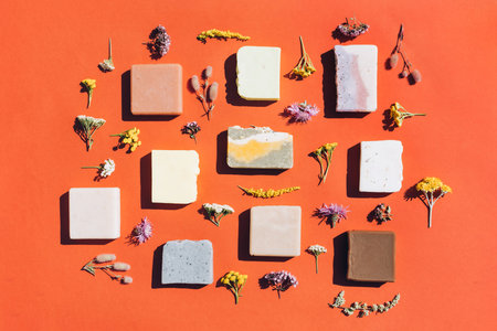 Modern flat lay composition with variety of handmade herbal organic soap bars made with natural...