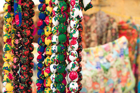 Colorful necklaces in folk or ethnic chic style as background with copy space. Handmade fabric...