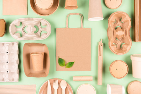 Flat lay style composition made with eco tableware bundle, paper utensils, paper bag and holders,...