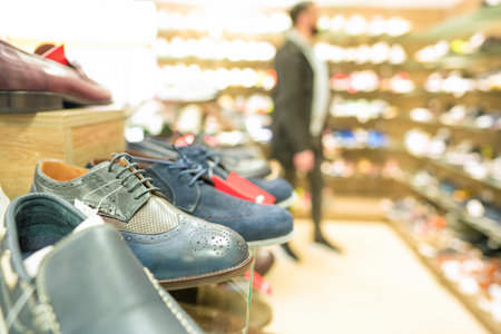 Shelves with different footwear at shoes store - new shoes collection at secondhand store. Reselling concept. Shoes stall at secondhand store. Thrift shoppingの写真素材